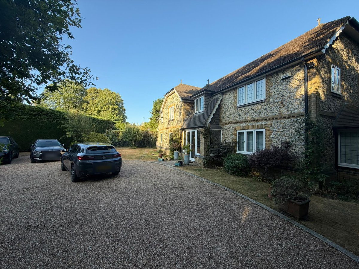 A large detached flint and brick property in Chipstead, Surrey, set behind a long gravel driveway typical of homes in the CR5 area