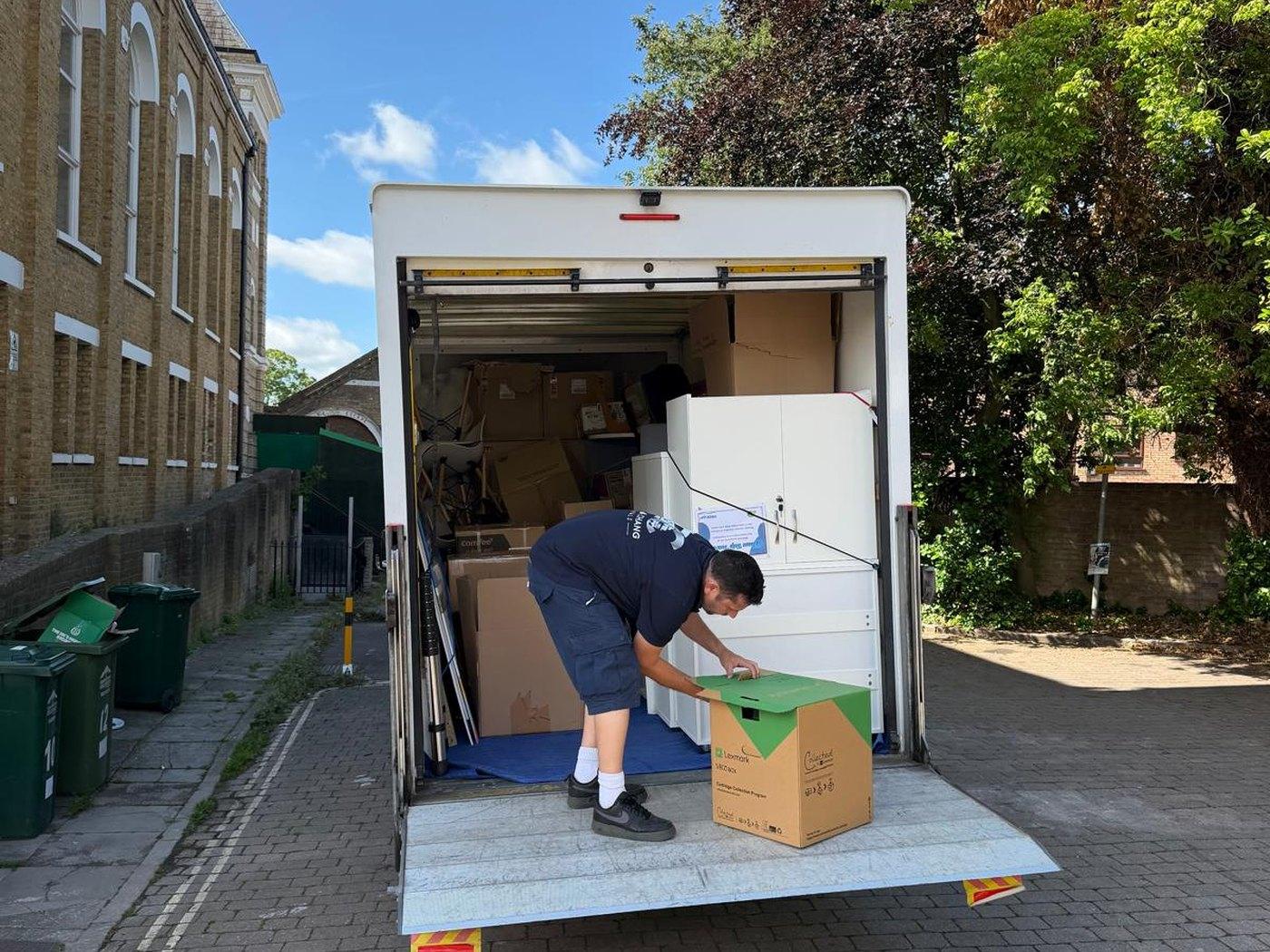 Taylor & Chang crew member in branded uniform unloading boxes