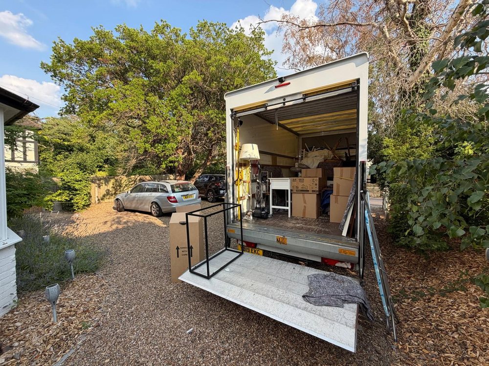 Removal van with tail lift lowered on a residential driveway