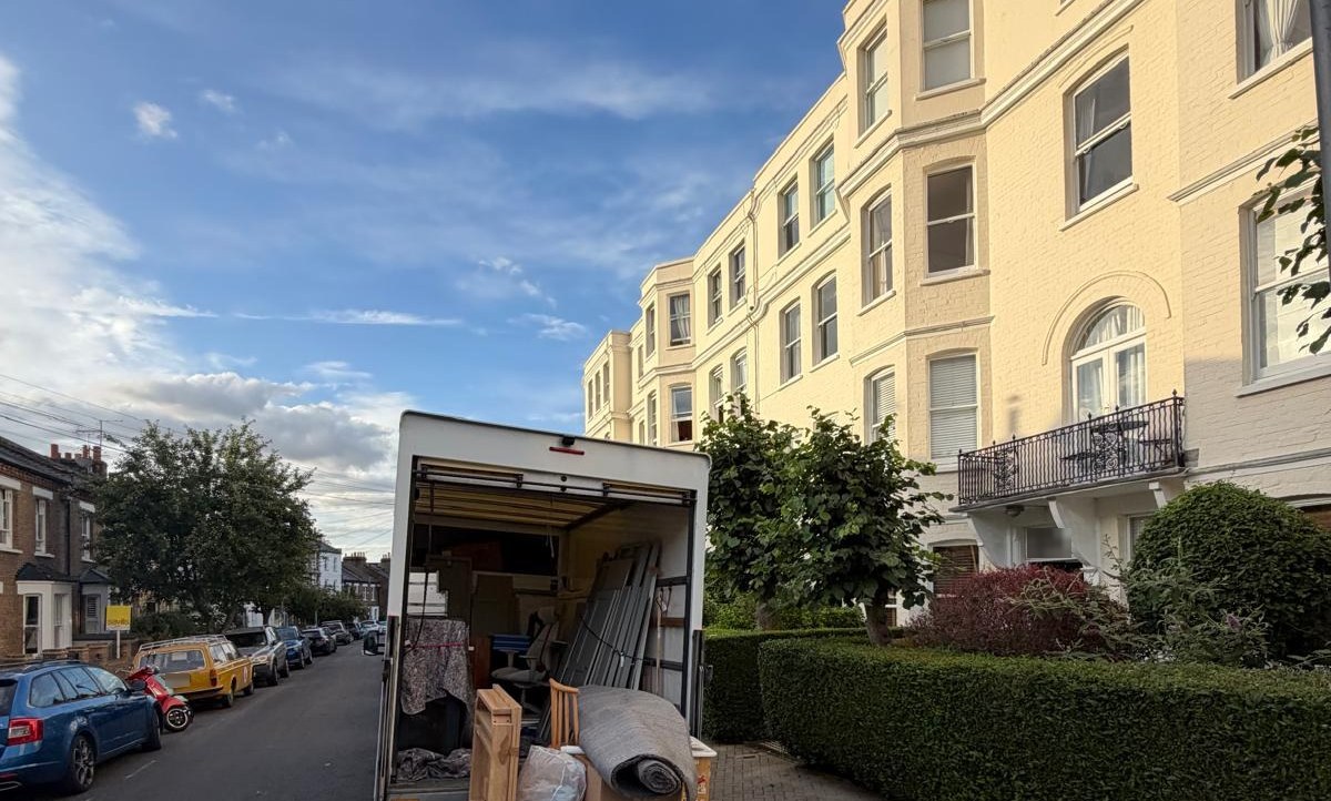 Taylor & Chang crew loading a sofa into the removal van outside a house